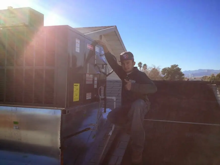 HVAC technician performing Heat Pump Repair on a rooftop unit in Hereford